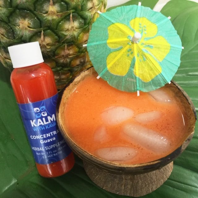 Guava Colada in Coconut Shell Bilo with cocktail umbrella and small bottle of Kalm with Kava guava concentrate