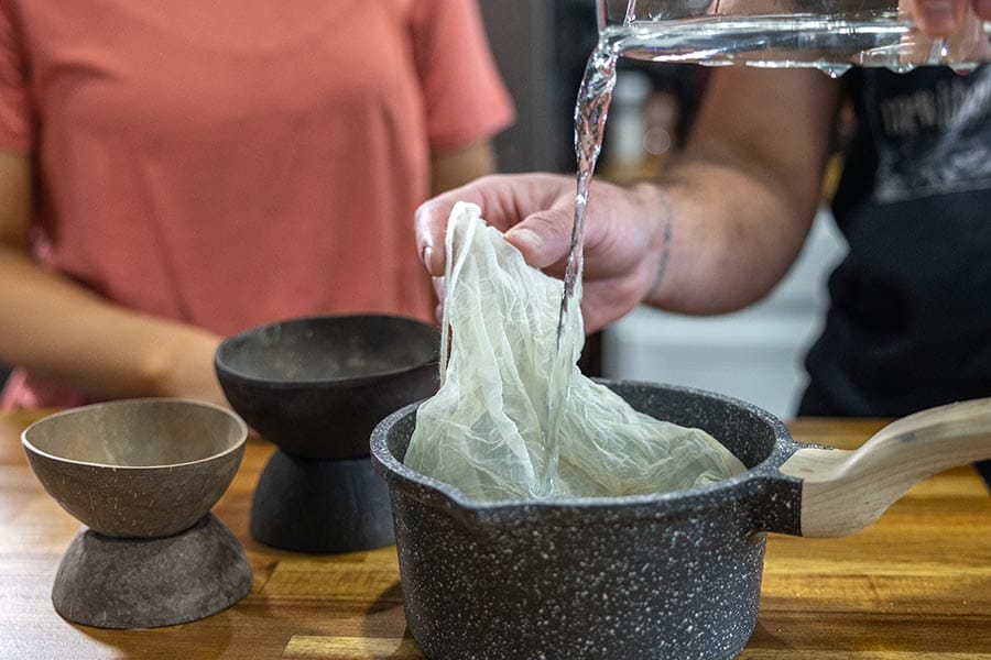 Making kava with the traditional method of a strainer